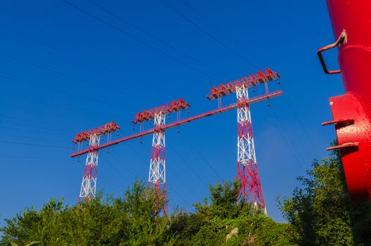 supports of high-voltage power lines against the blue sky