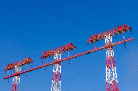 supports of high-voltage power lines against the blue sky