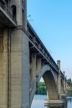road and rail split-level bridge over the river on a background of blue sky in the city