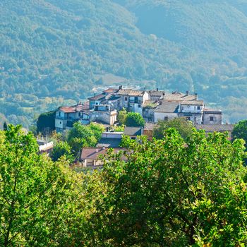 Medieval Italian City on a Hilltop Surrounded by Mountains Covered with Forests