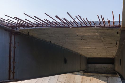 the construction of a bridge across the river with the supports, structural elements, cranes