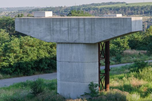 the construction of a bridge across the river with the supports, structural elements, cranes