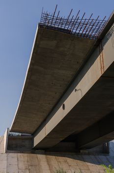 the construction of a bridge across the river with the supports, structural elements, cranes