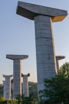 the construction of a bridge across the river with the supports, structural elements, cranes