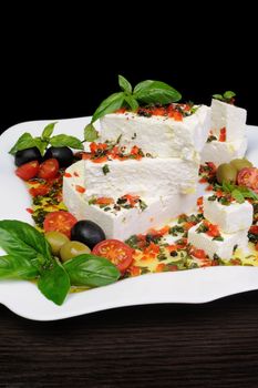 Pieces of feta   with basil and olives, cherry tomatoes