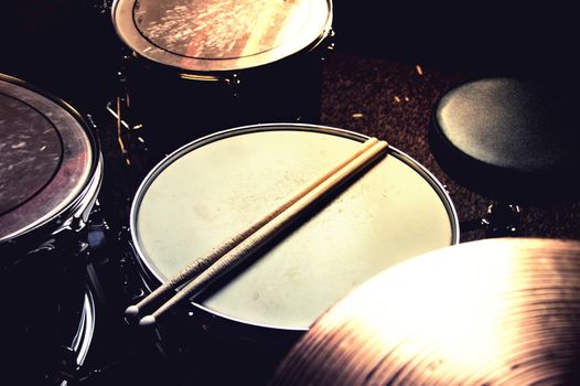 Drums conceptual image. Picture of drums and drumsticks lying on snare drum. Retro vintage instagram picture.