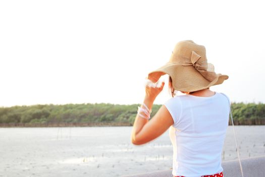 Lady at the beach with her brown hat