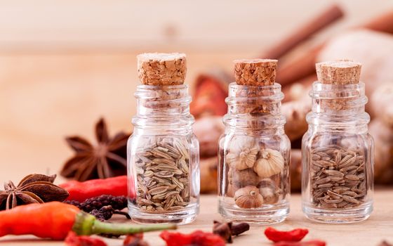 Assortment of Thai food Cooking ingredients in glass bottles on wooden background.