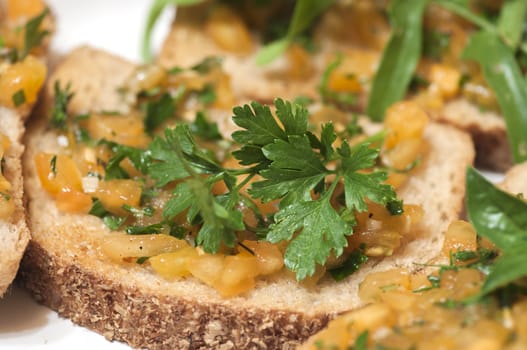 Italian bruschetta topped with yellow tomatoes and parsley