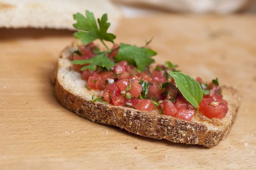 Italian bruschetta topped with tomatoes, parsley and basil