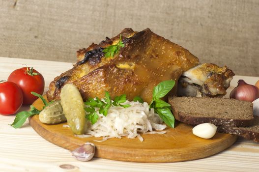 Roasted pork leg (rulka) served with sauerkraut, pickled cucumber, rye bread