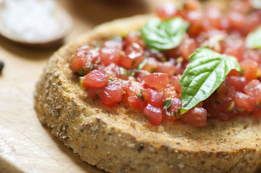 Italian bruschetta topped with tomatoes and basil, close up