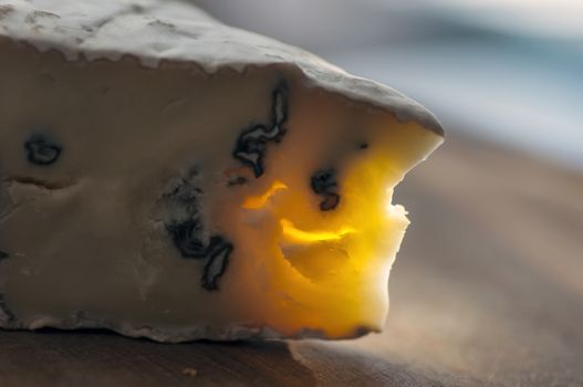 Cambozola cheese (combination of camembert and gorgonzola cheeses) on cutting board close up