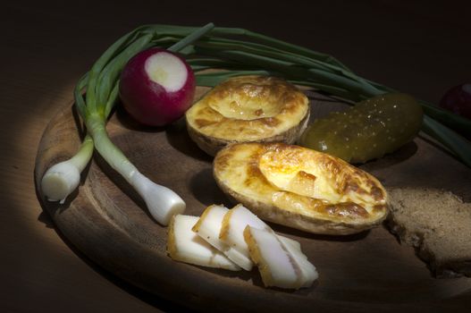 Baked potatoes in their jacket served with salted lard and green onion