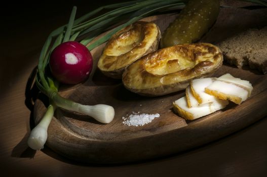 Baked potatoes in their jacket served with salted lard and green onion