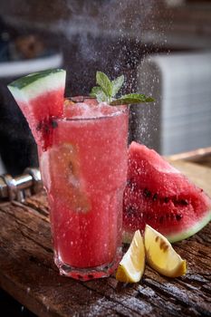 Homemade watermelon lemonade with mint and lemon in glasses and slices of watermelon