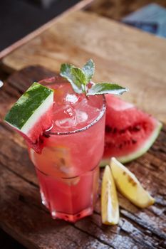 Homemade watermelon lemonade with mint and lemon in glasses and slices of watermelon