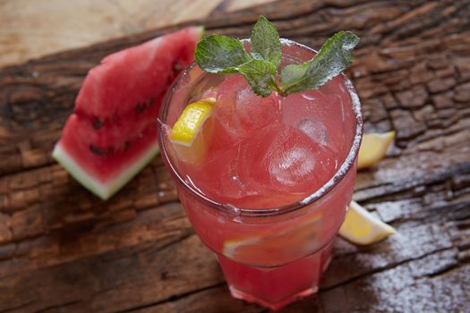 Homemade watermelon lemonade with mint and lemon in glasses and slices of watermelon