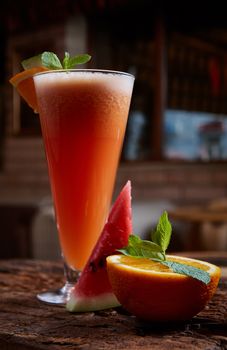 glass watermelon and orange smoothie with copy space on wooden background