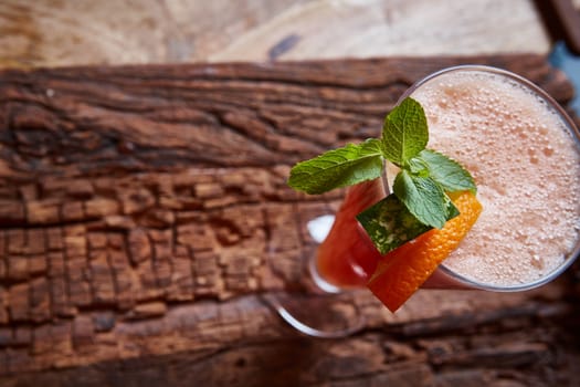 glass watermelon and orange smoothie with copy space on wooden background