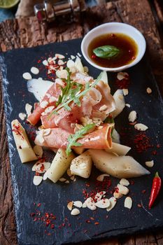 salad of fresh melon with thin slices of prosciutto, arugula leaves and balsamic sauce top view