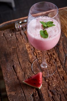 Healthy watermelon and melon smoothie with copy space on a wood background