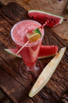 Healthy watermelon and melon smoothie with copy space on a wood background