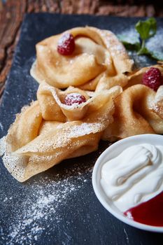 Crepes with raspberries with copy space on black background