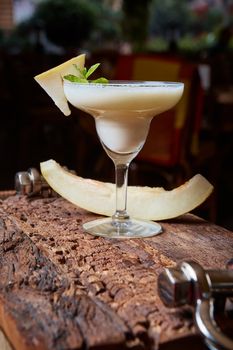 margarita melon cocktail with copy space on wooden background. 