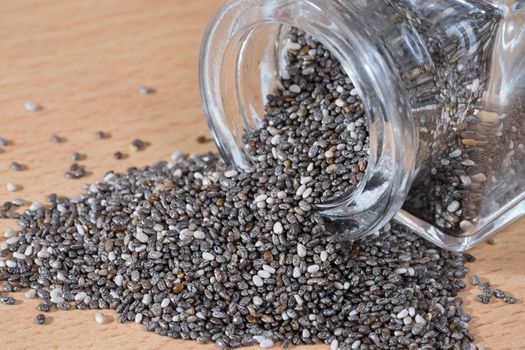 pouring chia seeds from a glass bottle