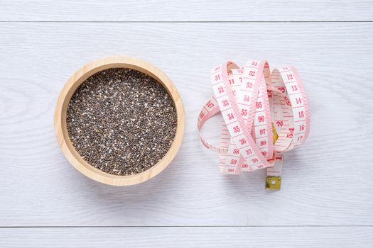chai seeds and tape measure on white wooden table