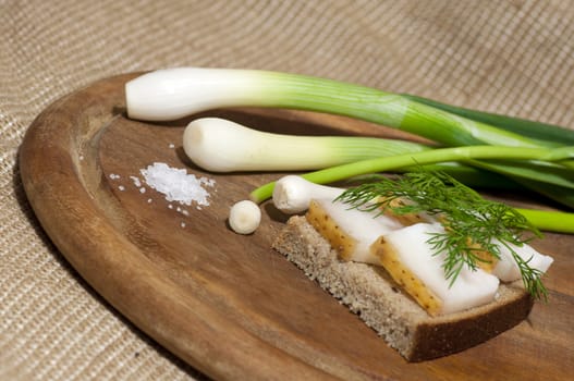 Sandwich with salted lard on rye bread served with green onion and garlic