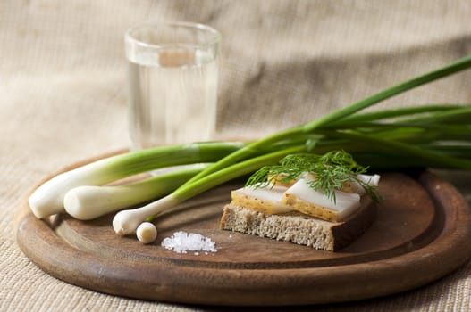 Sandwich with salted lard on rye bread served with vodka, green onion and garlic