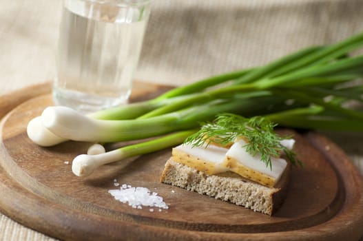 Sandwich with salted lard on rye bread served with vodka, green onion and garlic