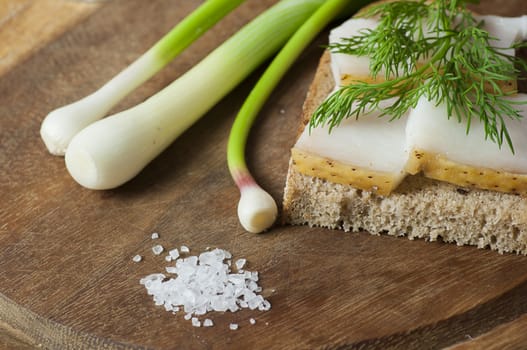 Sandwich with salted lard on rye bread served with green onion and garlic