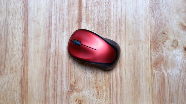 black red wireless mouse on wooden table.