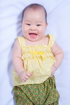 top-view asian baby girl in traditional thai dress, she lie down, smile  and looking at camera