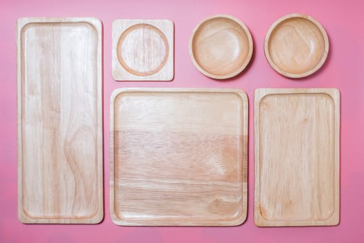 Group of wooden plate and bowl on pink background