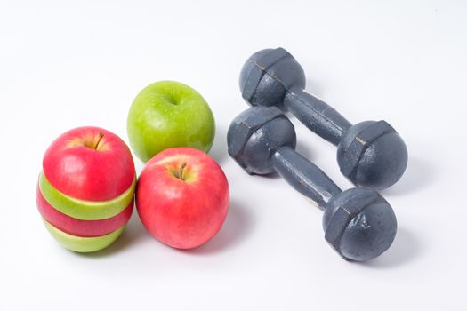 slice red and green apples with dumbbell on white background