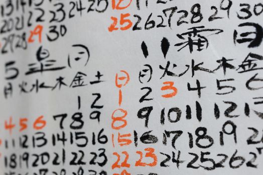 Some hand written numbers and Kanji on a Japanese Calendar.
