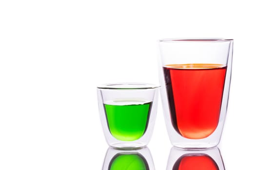Glass of red and green  water, like a tomato juice, carrot juice, soft drink, vegetable juice,