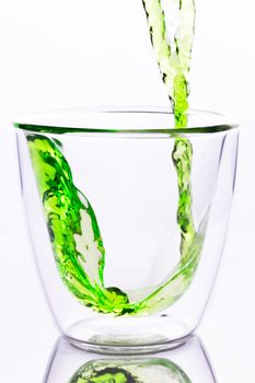 pouring green water in to clear two layers glass