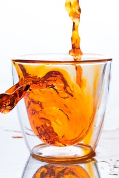 pouring orange water in to clear two layers glass, this orange water look like whisky, spirits