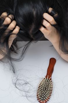 woman hair loss problem , she stress
 looking on her hair loss in her hand