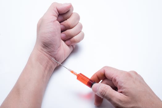 Drug addict man with red drung syringe in action