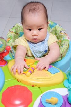 Asian thai baby play her colorful toy on seat