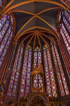 Stained Glass Cathedral Ceiling Altar Saint Chapelle Paris France.  Saint King Louis 9th created Sainte Chappel in 1248 to house Christian relics, including Christ's Crown of Thorns.  Stained Glass created in the 13th Century and shows various biblical stories along wtih stories from 1200s.