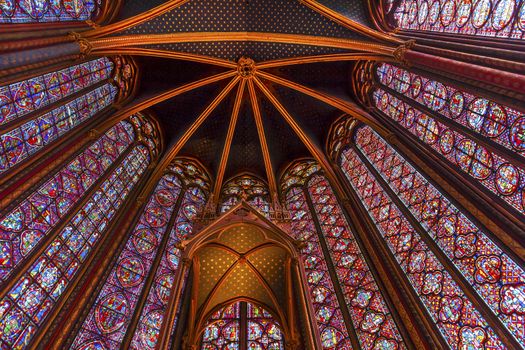 Stained Glass Cathedral Ceiling Saint Chapelle Paris France.  Saint King Louis 9th created Sainte Chappel in 1248 to house Christian relics, including Christ's Crown of Thorns.  Stained Glass created in the 13th Century and shows various biblical stories along wtih stories from 1200s.