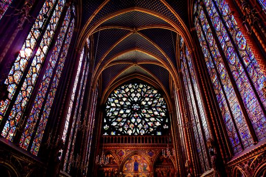 Rose Window Stained Glass Cathedral Ceiling Saint Chapelle Paris France.  Saint King Louis 9th created Sainte Chappel in 1248 to house Christian relics, including Christ's Crown of Thorns.  Stained Glass created in the 13th Century and shows various biblical stories along wtih stories from 1200s.