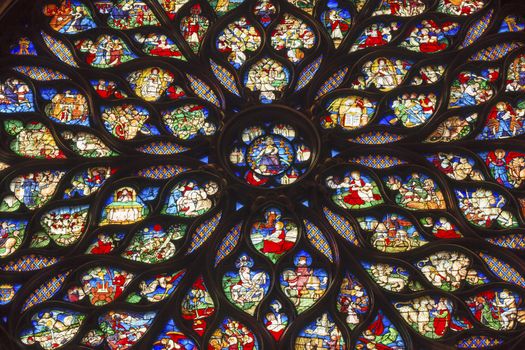 Jesus Christ With Sword Surrounded by Biblical and Medieval Stories Angels, Mary Rose Window Stained Glass Saint Chapelle Paris France.  Saint King Louis 9th created Sainte Chappel in 1248 to house Christian relics, including Christ's Crown of Thorns.  Stained Glass created in the 13th Century and shows various biblical stories along wtih stories from 1200s.